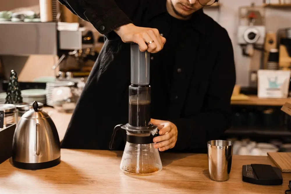 barista preparing aeropress coffee in the kitchen