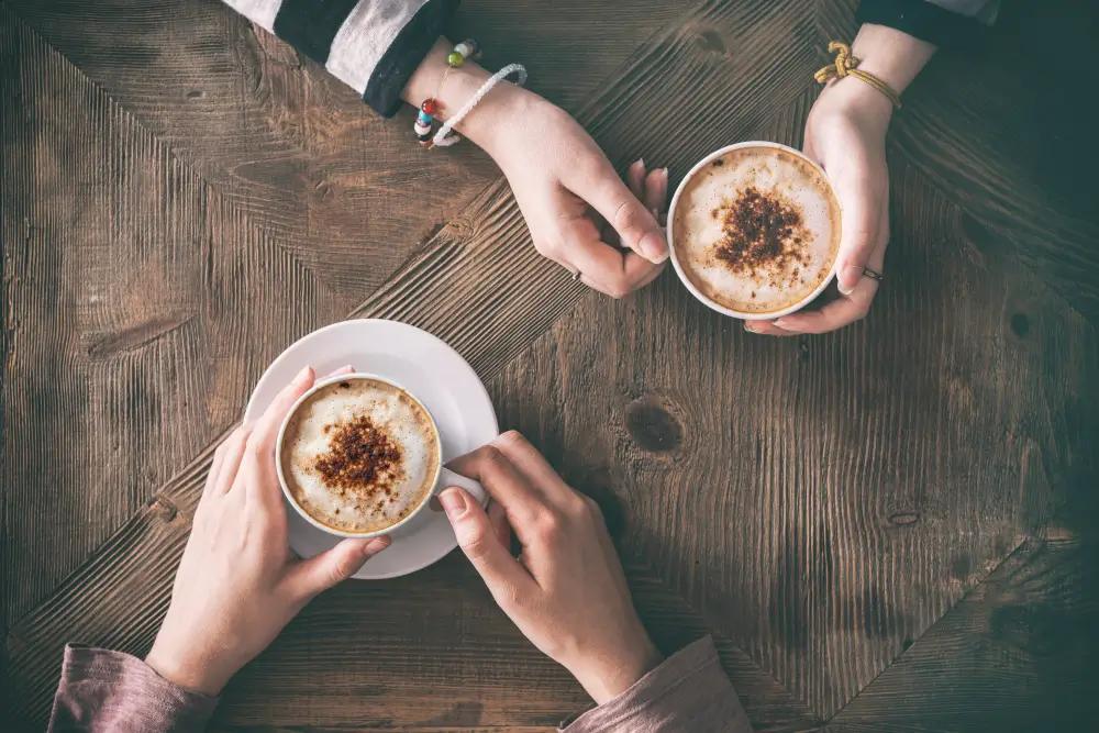 an aesthetic topdown shot of two coffee cups placed on a table shot