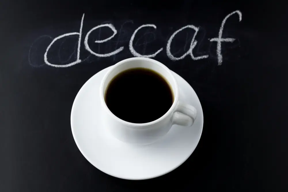 decaf coffee placed on a black counter top with text written on the back "decaf"